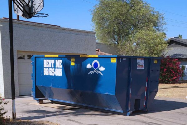 A blue dumpster with a painted message that reads, 
