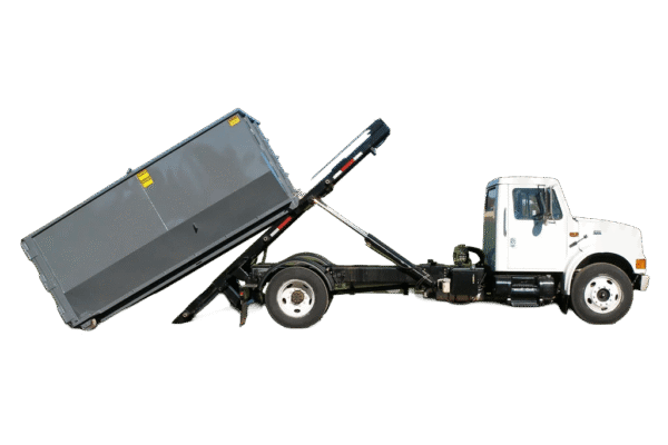 A white truck outfitted with a roll off hoist, dropping a gray dumpster at a job site