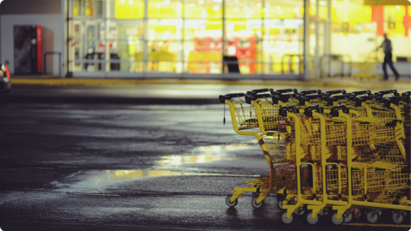 Yellow shopping carts in a retail business parking lot at night